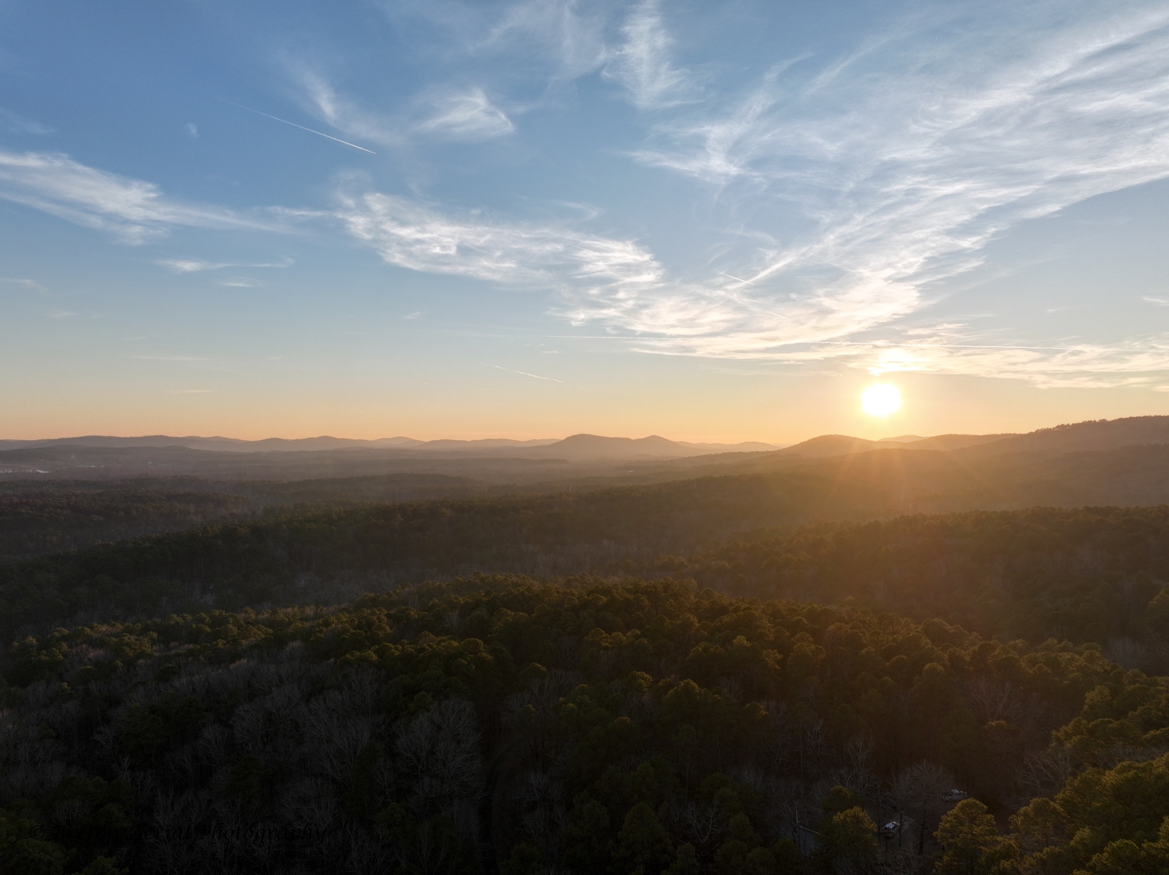 Sunset over forested mountains photographed from above